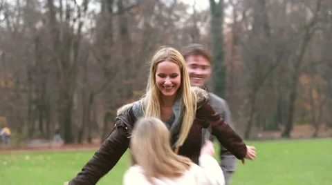 Father and daughter playing around mother in park Stock Footage 59554485