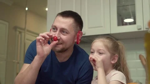 Father and daughter posing for the camera with vegetables, creating creative Stock Footage 303578140