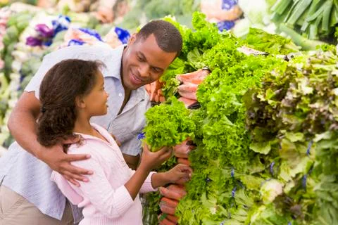 Father and daughter shopping for lettuce at a grocery store Stock Photos