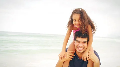 Father and daughter smile on a beach Stock Footage
