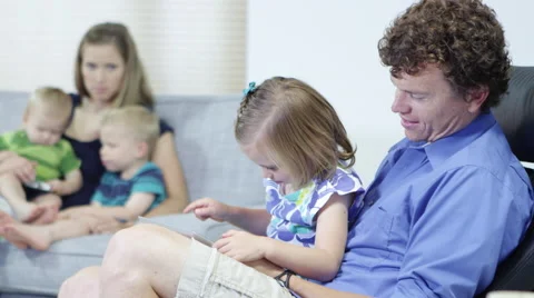 Father and daughter using tablet with family in the living room Video stock 67297536