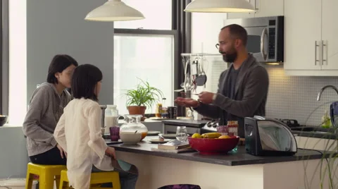 Father and daughters having breakfast in kitchen Stock Footage 63860909