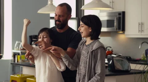 Father and daughters having fun together in kitchen Stock Footage 63860829