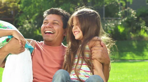 Father and daughters hug each other in a park Stock Footage 33897331