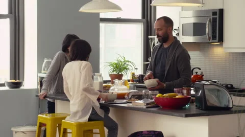 Father and daughters interacting while having breakfast in kitchen Stock Footage 63860976