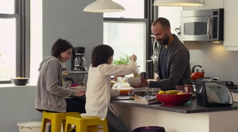 Father and daughters interacting while having breakfast in kitchen Stock Footage 63860993