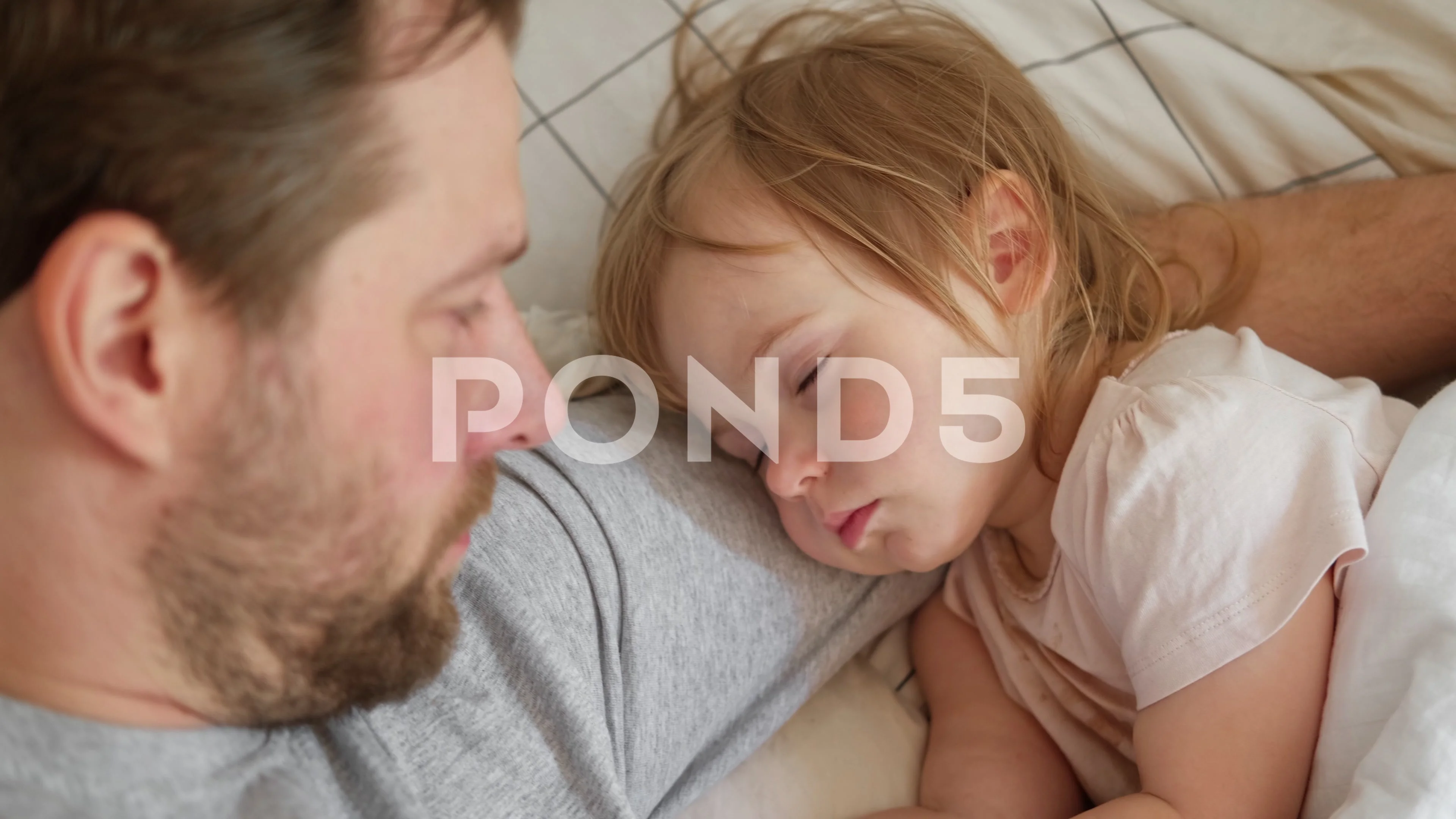 Father and his little daughter toddler girl sleeping together. Single dad