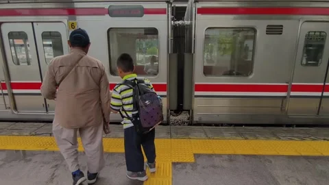 A father and his son boarded a train that stopped at the station Stock Footage 310092126