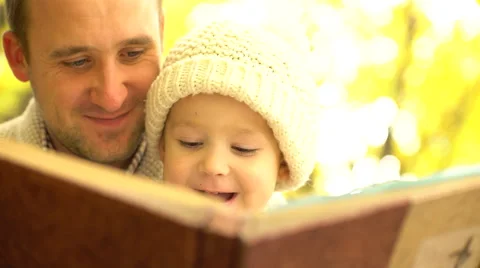 Father and his son having fun in study interesting book in yellow autumn forest Stock Footage 68956545