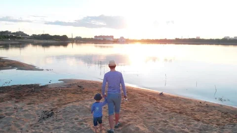 A father and his son in pair clothes walking on fishing on the river coast Stock Footage 111427889