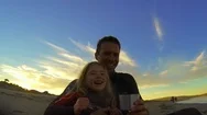 Father And His Young Daughter Laugh Together As They Relax On The Beach With A Stock Footage