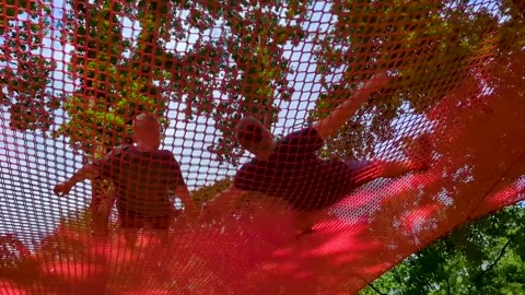 Father and his young son having fun together jumping and playing in an outdoor n Stock Footage 343617660