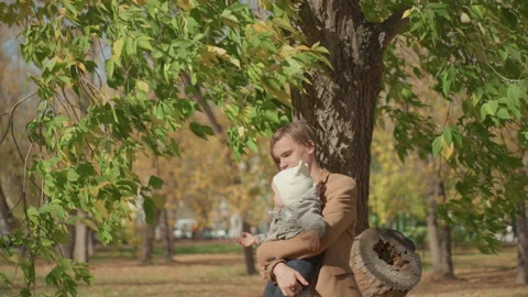 Father and infant sharing tender moments in autumn park. Warmhearted parent 動画素材 331526604