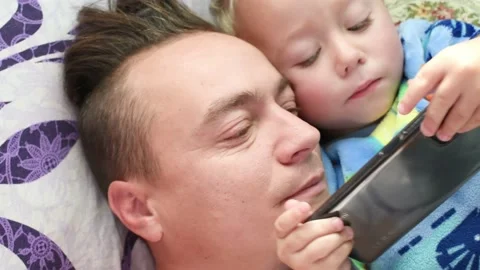 Father and kid boy son touching screen of smartphone in the morning, Morning Stock Footage 219480281