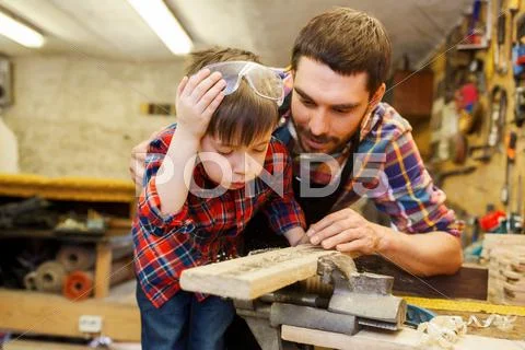 Father and little son with wood plank at workshop Stock Photos