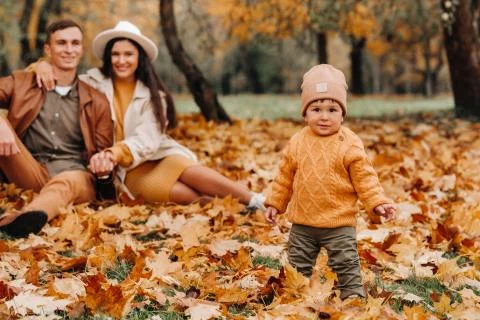 Father and mother with son walking in the autumn Park. A family walks in the Stock-Fotos