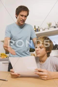 Father and son (13-14), Boy with report card, Man gesturing Stock Photos