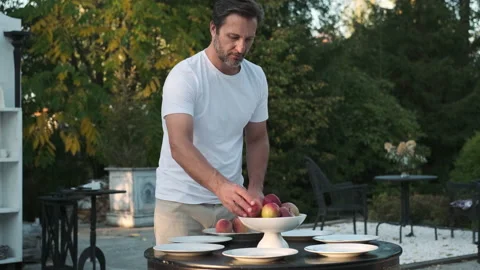 Father and son are preparing a table for dinner on the street near the house. Stock Footage 217809920