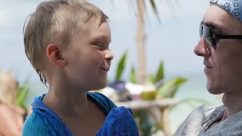 Father and son are sitting opposite each other, close up. father is sitting with Stock Footage 127149943