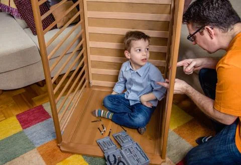 Father and son assembling cot for a newborn at home Stock Photos
