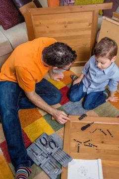 Father and son assembling a new furniture for home Stock Photos