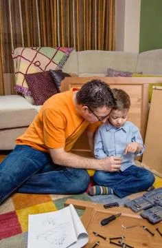 Father and son assembling a new furniture for home Stock Photos