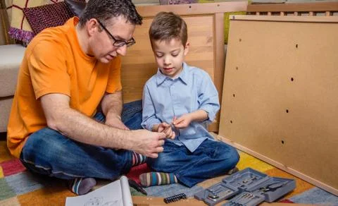 Father and son assembling a new furniture for home Stock Photos