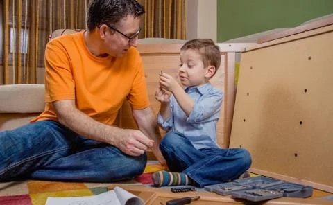 Father and son assembling a new furniture for home Stock Photos