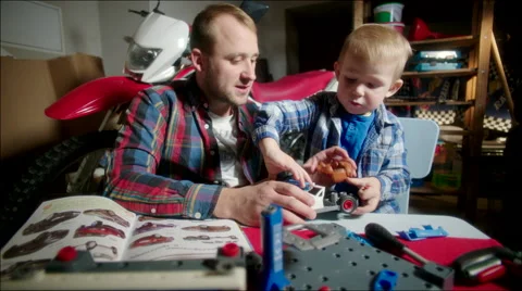 Father and Son Assembling the Toy Car from Parts Stock Footage 62217811