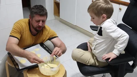 Father and son baking cookies together in kitchen Stock Footage 314468088