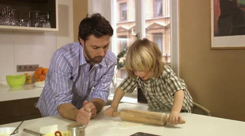 Father and son baking using a rolling-pin, Stockholm, Sweden. Stockbeeldmateriaal 51815997