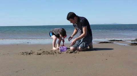 Father and Son On The Beach Making Sandcastles Stock Footage 60963706