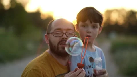 Father and son blow bubbles, have fun with the family, the child has fun with hi Stock Footage 164618751