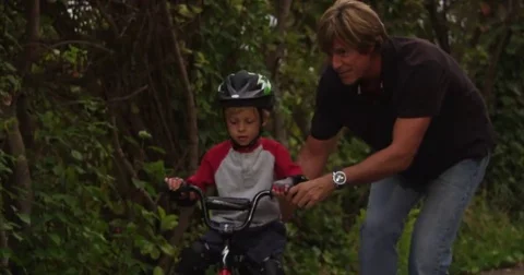 Father and son bond while learning to ride a bike. Stock Footage 69195570