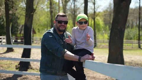 Father and Son Bonding Time at Park. Man holding a child in a park on a sunny Stock Footage 266330904