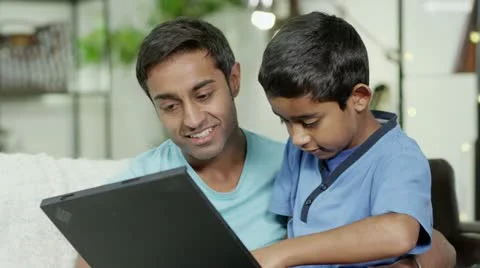 Father and son browsing the internet on a laptop computer Stock Footage