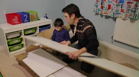 Father and Son Build A Flat Pack Wardrobe Stock Footage 60823917