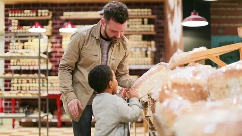 Father and son buying bread in grocery store Stock Footage 73506853