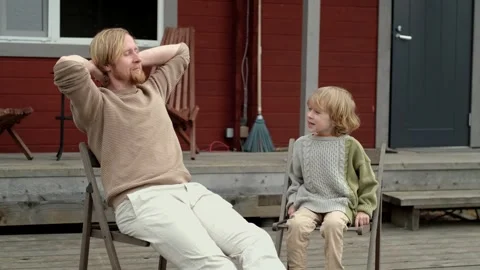 Father and son chatting while sitting on the terrace Stock Footage 307005397