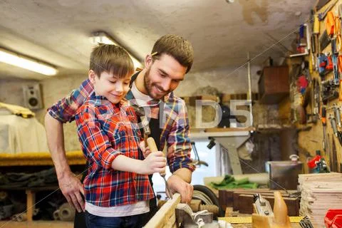 Father and son with chisel working at workshop Stock Photos