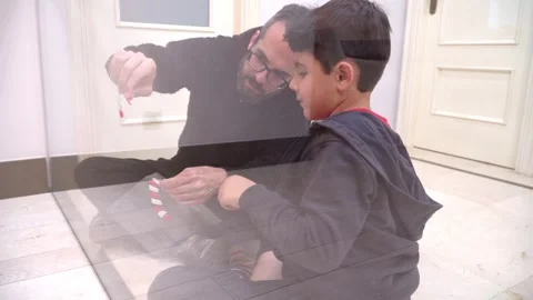 Father and son decorating glass door with sugar cane for Christmas Stock Footage 345253193