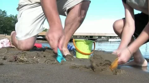Father and Son Dig in Beach Sand Video stock 12579324
