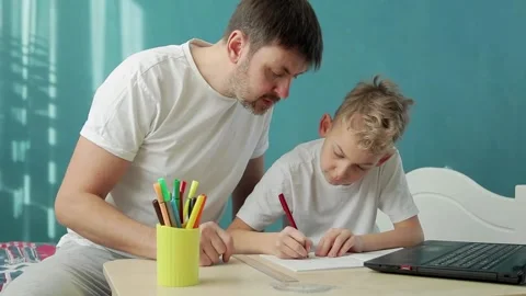 Father and son do homework remotely in front of notebook Video stock 149835880