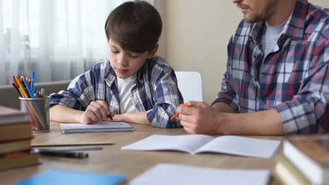Father and son doing homework together, dad explaining task, school education Video stock 88216409