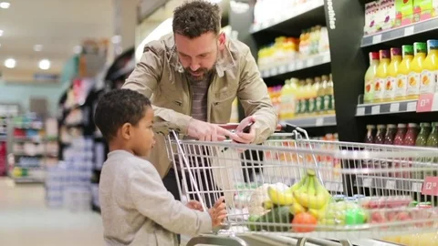 Father and son doing weekly shop in grocery store Stock Footage 73506686