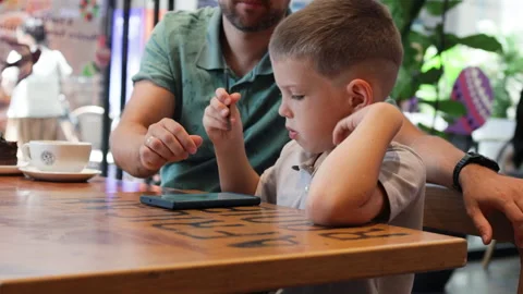 Father and son drawing by stilus in phone. Video stock 289701465