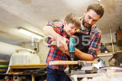 Father and son with drill working at workshop Stock Photos