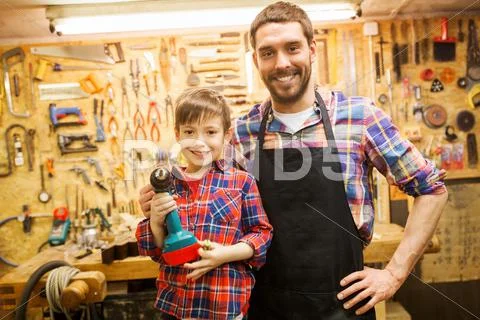 Father and son with drill working at workshop Stock Photos