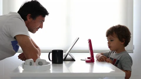 A father and a son each using an electronic tablet shake hands Stock Footage 131540387