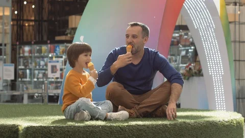 Father and son enjoying icecream outside in a park Video stock 128249953